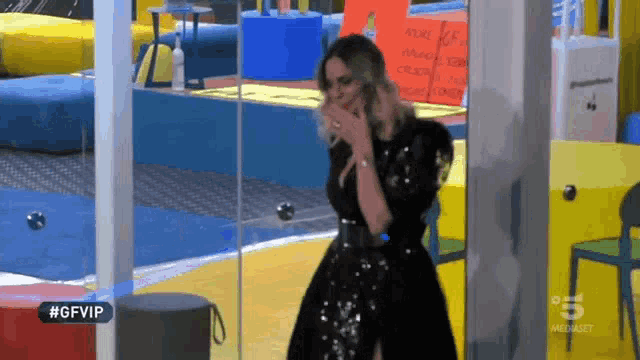 a woman in a black dress is standing in front of a glass door with #gfvip written on the bottom
