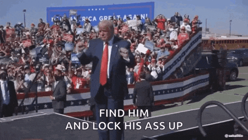 a man in a suit and tie stands in front of a crowd and says find him and lock his ass up .
