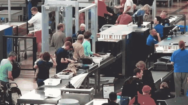 a group of people at a security checkpoint with a sign that says ' united airlines '