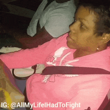 a woman in a pink shirt is sitting in a car with the hashtag allmylife had to fight