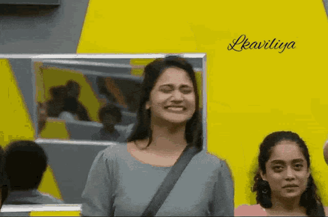a woman is smiling in front of a yellow wall with the name leavitiya written on it