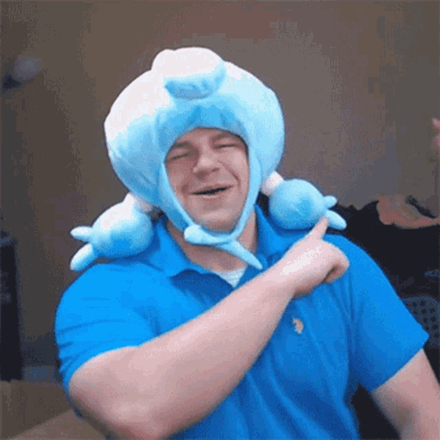 a man wearing a blue polo shirt and a blue stuffed hat