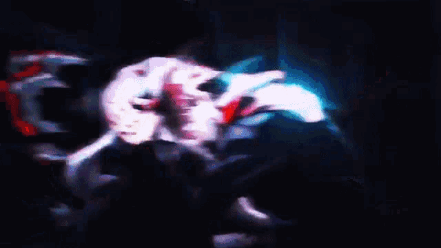 a blurry image of a person 's face in a dark room with a lot of colors
