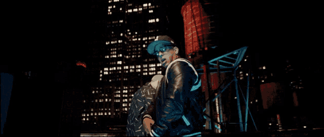 two men are standing in front of a building at night and one is wearing a mask