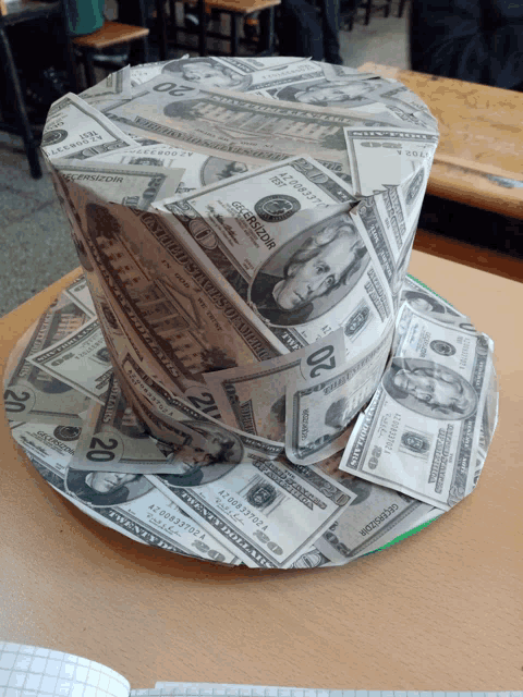 a top hat made out of twenty dollar bills on a table