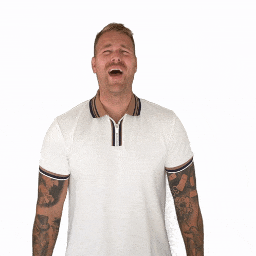 a man with tattoos on his arms is laughing with his mouth wide open
