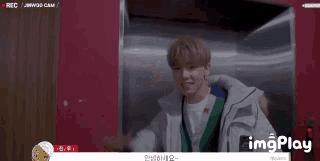a young man in an elevator is being recorded by a camera with imgplay written on the bottom