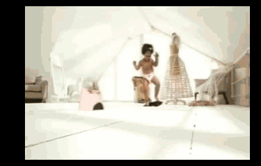 a little girl is standing on a stool in a room