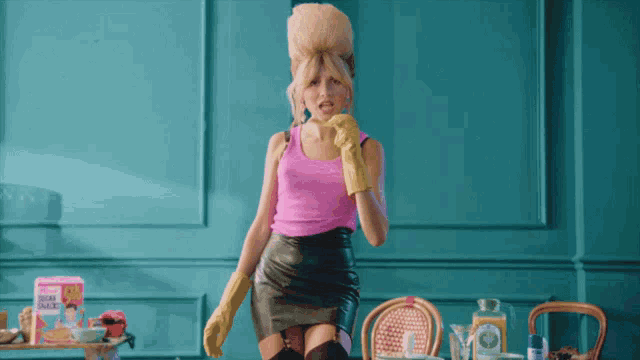 a woman in a pink tank top and a black skirt stands in front of a box of granola bars