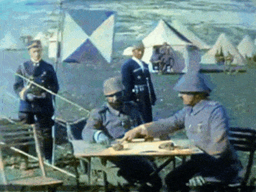 a group of soldiers are gathered around a table with a flag in the background