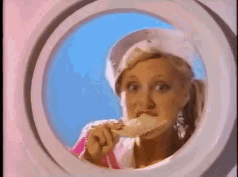 a woman is eating ice cream through a window in a washing machine .