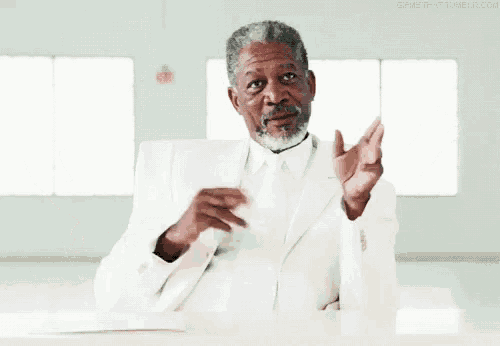 a man in a white suit and tie is saying i am god