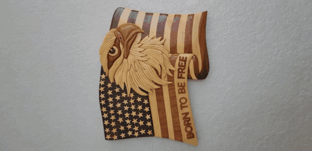 a wood carving of an american flag with the words born to be free