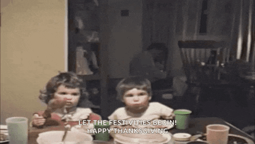 a boy and a girl are sitting at a table eating food and drinking milk .