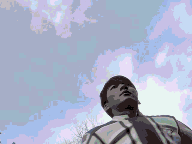 a man is raising his fist in the air against a cloudy sky .