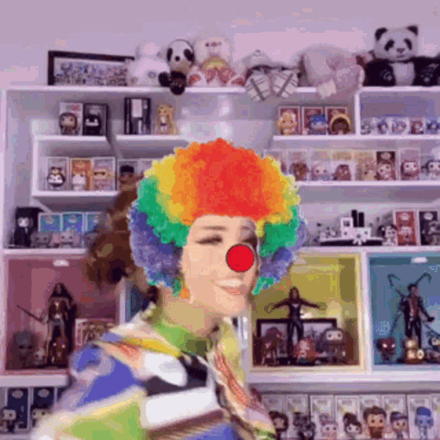 a woman in a clown costume is standing in front of a shelf filled with toys .