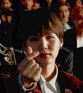 a young man making a heart shape with his finger