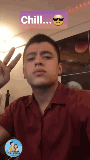 a man in a red shirt is giving a peace sign with a sticker that says chill