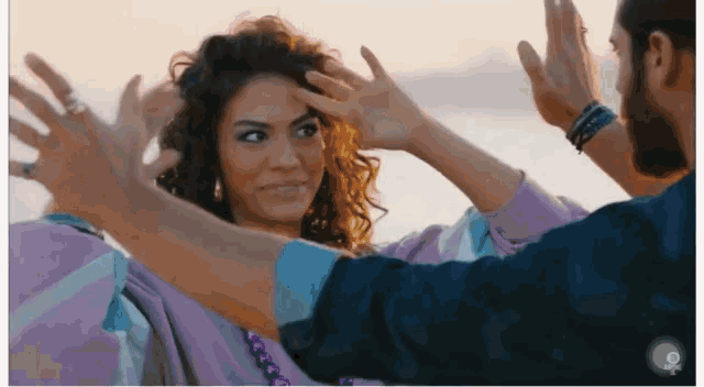 a man and a woman are giving each other a high five on a beach