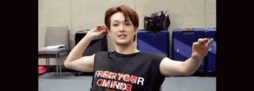 a man in a black shirt is flexing his muscles in a gym .