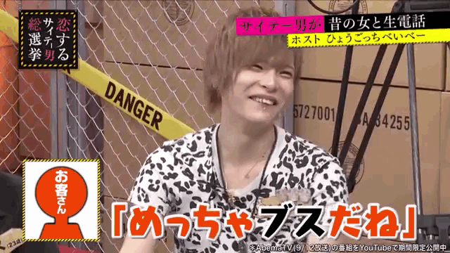 a man is smiling in front of a yellow tape that says danger on it