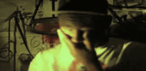 a man wearing a hat covering his mouth with his hand