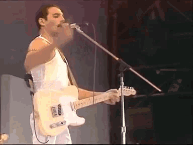 a man is singing into a microphone while holding a guitar .