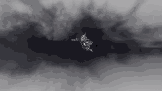 a black and white image of a person flying through a cloudy sky