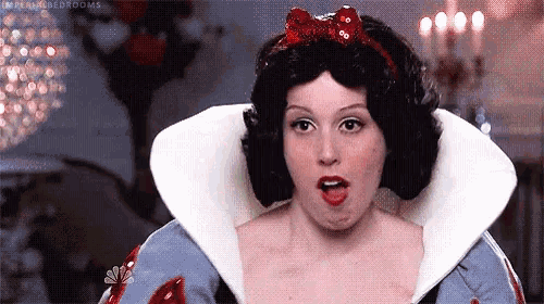 a woman in a snow white costume is making a funny face .