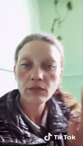 a woman wearing a black jacket is making a funny face .