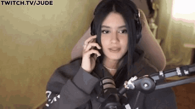 a woman wearing headphones is sitting in front of a microphone .