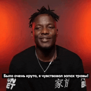 a man wearing a black shirt that says un et is smiling