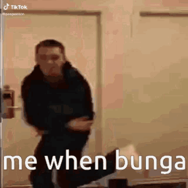 a man is standing in front of a door with the words `` me when bunga '' written on it .