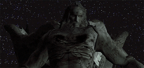 a statue of a man with a beard is in the middle of a starry night sky