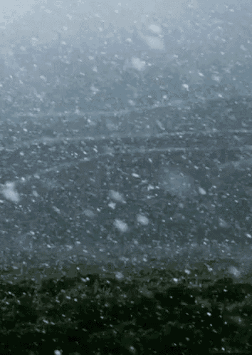snow is falling on a dark gray surface