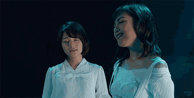 two women are standing next to each other and the word drop is on the bottom of the image
