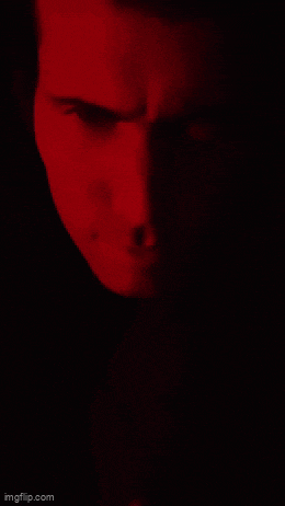 a close up of a person 's face with a red light behind them .