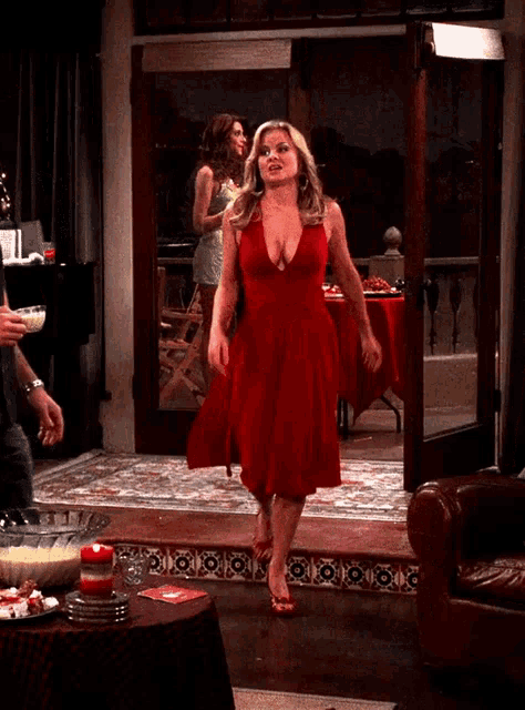 a woman in a red dress is walking in a doorway