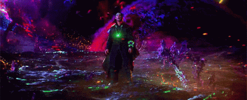 a person is standing in a dark room with a green light coming out of their hand .