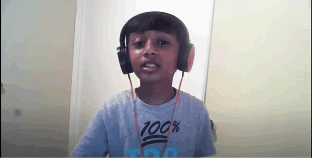 a young boy wearing headphones and a 100 % shirt