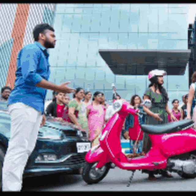 a man in a blue shirt is talking to a woman on a scooter