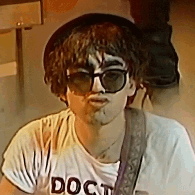 a man wearing sunglasses and a doct shirt