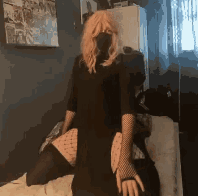 a woman wearing a black dress and fishnet gloves is standing in front of a mirror .