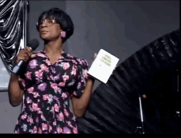 a woman in a floral dress is holding a piece of paper that says ' truth in faith ' on it
