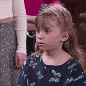 a little girl with a bow in her hair is wearing a butterfly shirt .