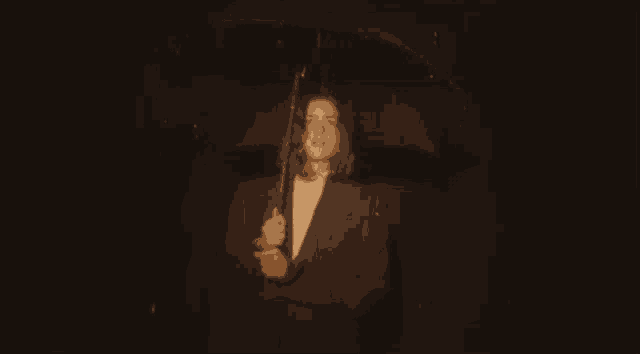 a man in a suit holding an umbrella in the rain