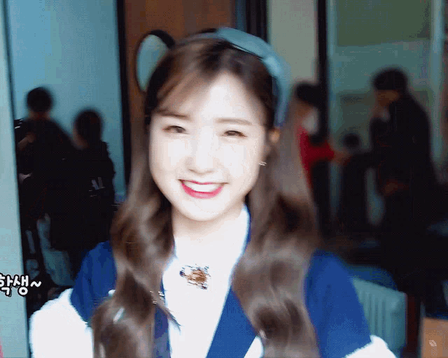 a woman wearing a headband and a blue shirt smiles