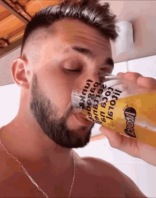 a man is drinking from a glass that says boo