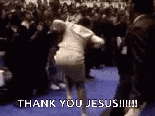 a man is running in front of a crowd with the words thank you jesus written on the screen .