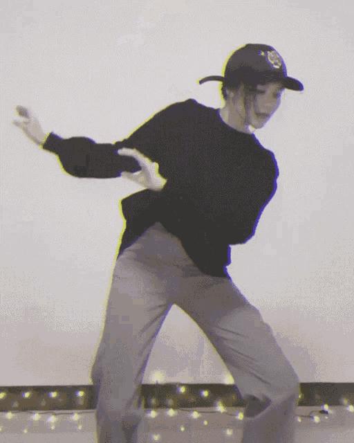 a person wearing a black sweater and gray pants